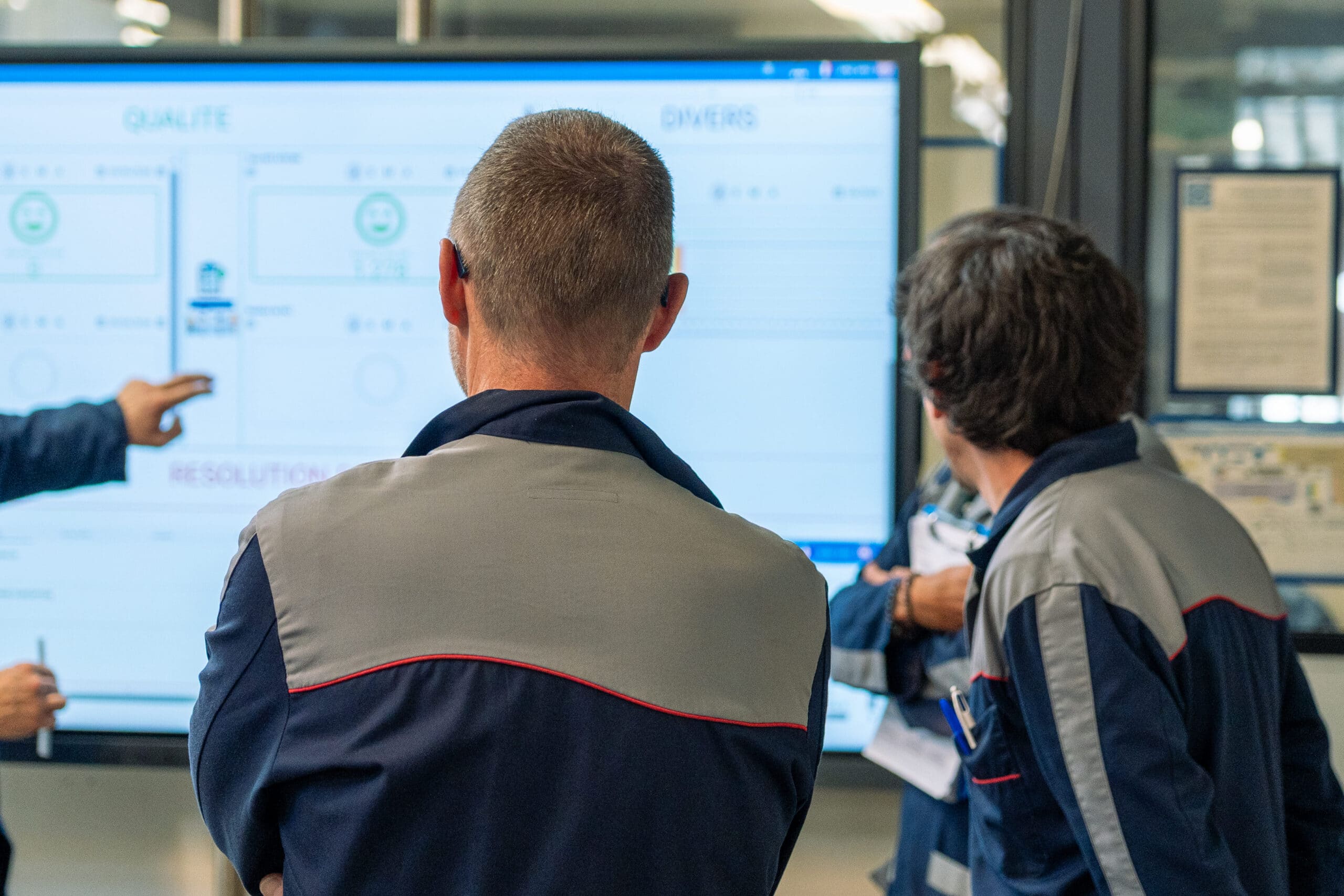Opérateurs suivant la production et les indicateurs qualité sur un écran